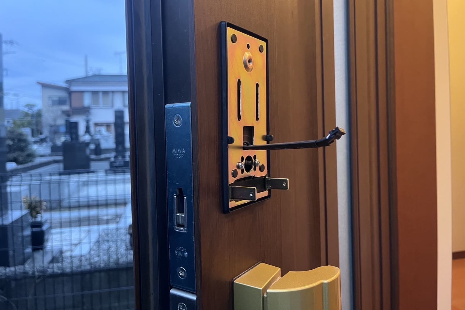交換中の玄関の鍵(電子錠を取り付け配線を室内に通す)