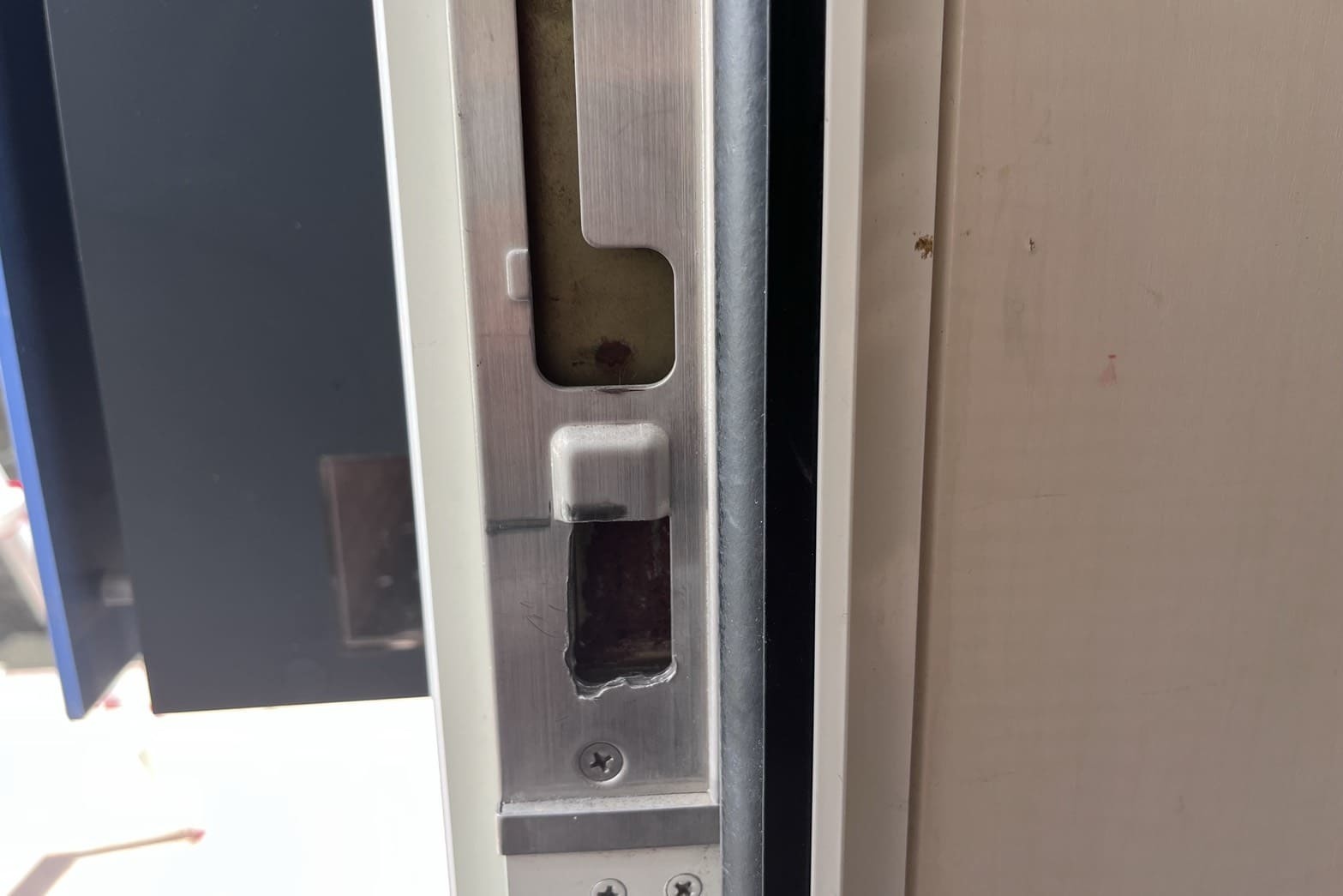 修理前の玄関の鍵（ストライクにデッドボルトが当たっている）